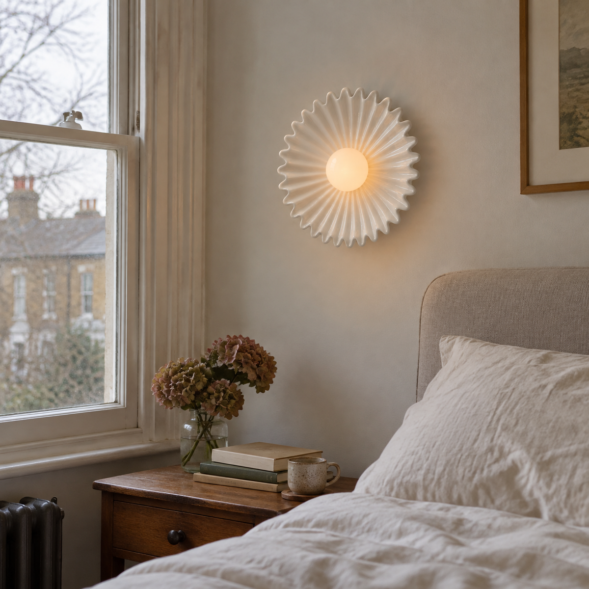 Ceramic flower wall light beside a bed