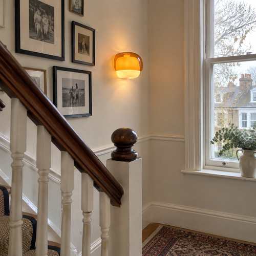 Coloured glass wall sconce on a landing