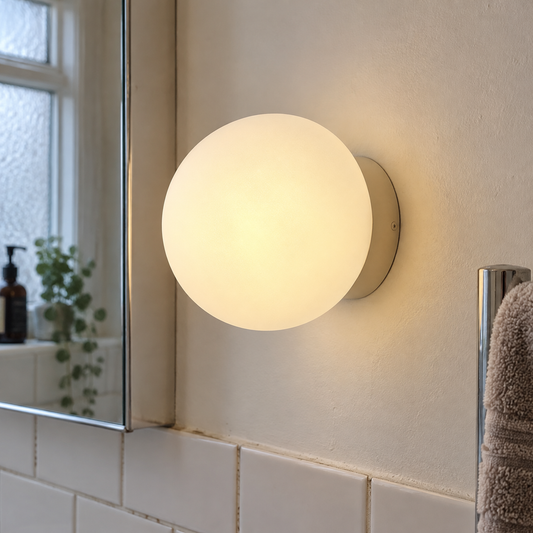 Frosted glass orb wall sconce in a bathroom