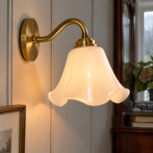 French glass wall sconce mounted on the wall with the shade upright in its fitting, in a panelled hallway