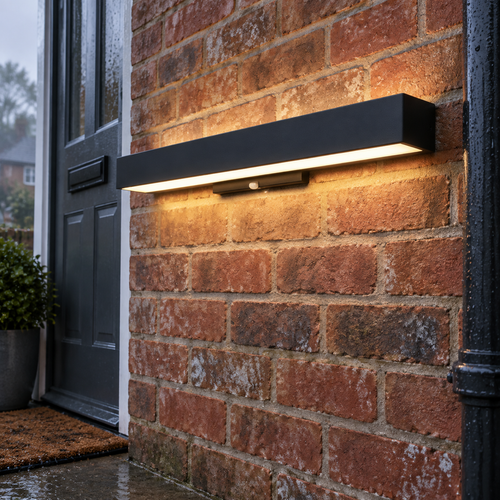 Black rectangular outdoor LED wall light mounted beside a front door on a misty afternoon