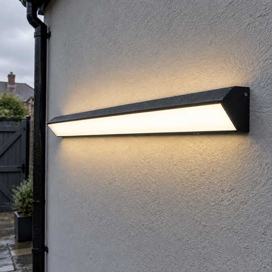 Long IP65 linear outdoor wall light on a rendered British house wall in grey weather