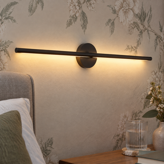 Aluminium linear LED wall light above a British bedside table