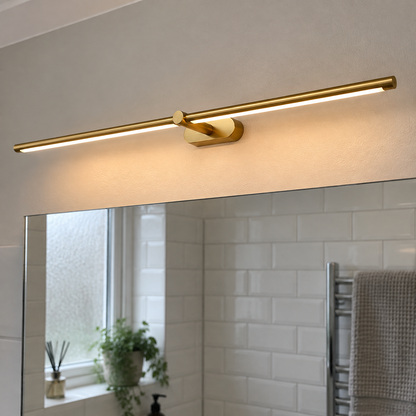 Slim minimalist linear wall light mounted above a British bathroom mirror