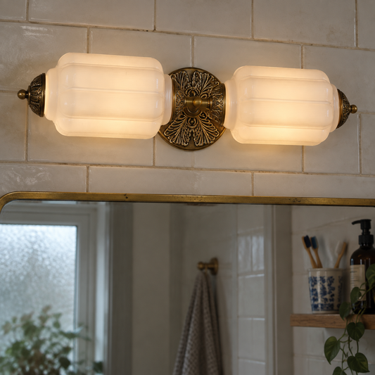 Art deco milk glass vanity light mounted above a British bathroom mirror