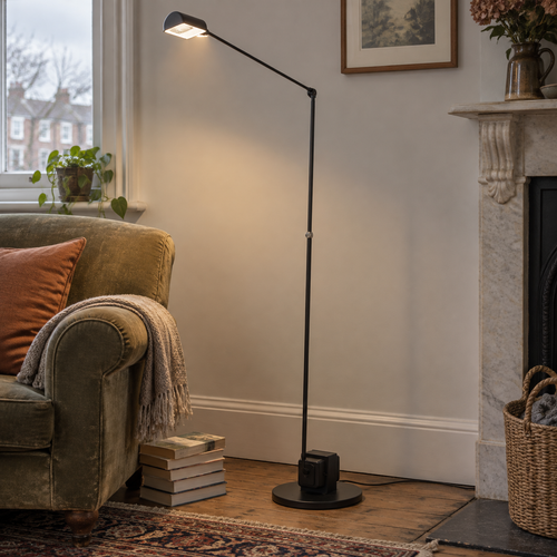 Slim mid-century floor lamp standing beside a reading chair in a British sitting room