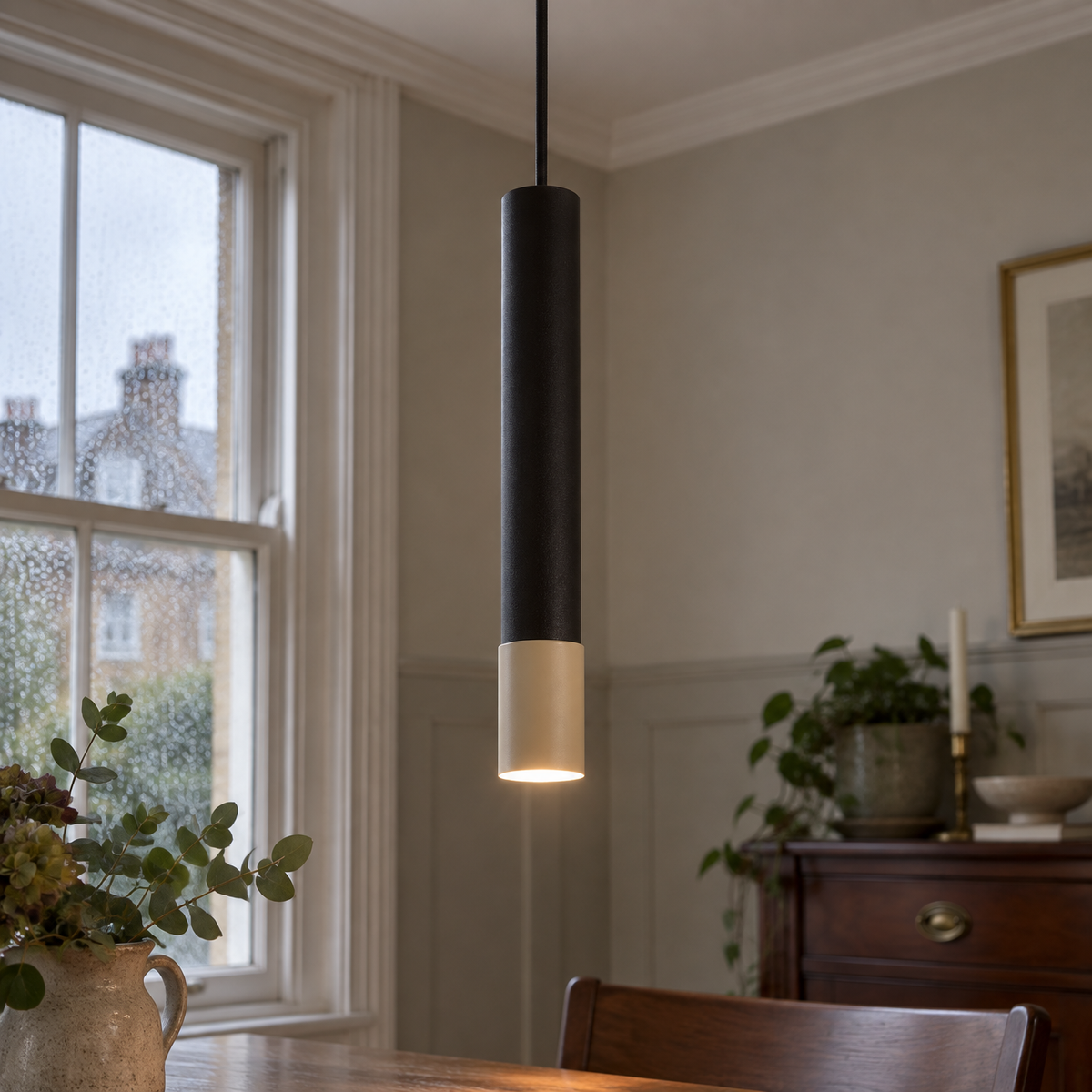 Glass and aluminium pendant light hanging over a dining table in a British home