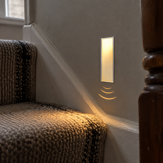 Recessed motion sensor stair light washing light across the treads of a British staircase