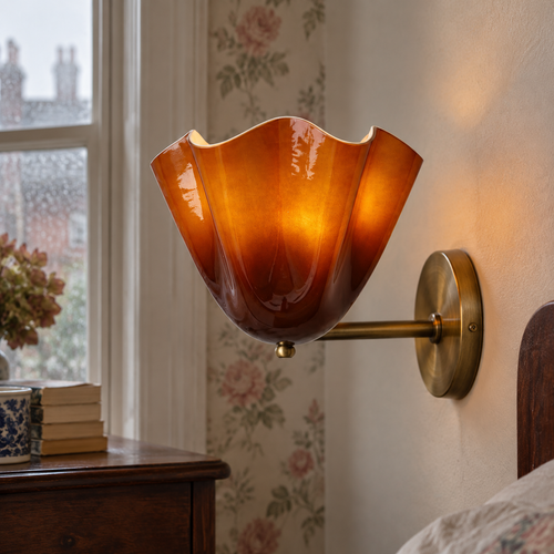 Murano glass floral wall lamp mounted beside a bed, its hand-blown flower shade glowing against faded floral wallpaper