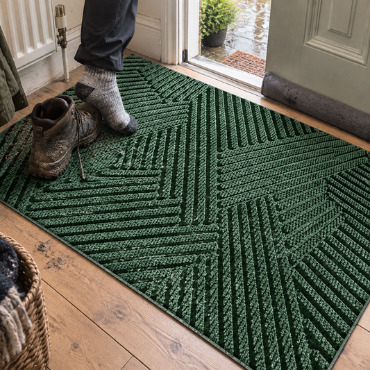 Non-slip dirt-resistant door mat inside a front door as muddy boots are stepped off onto it