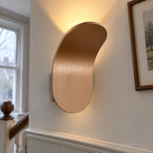 Nordic minimalist LED wall lamp lit on a landing wall beside a banister and framed print