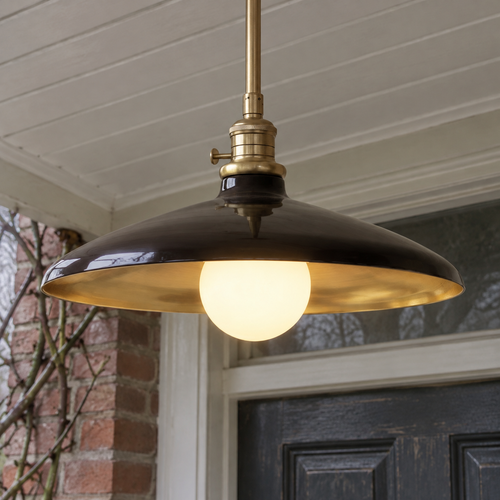Metal and clear glass outdoor lantern pendant hanging lit in a porch on a misty day