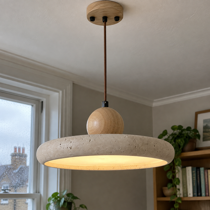 Modern ceiling pendant lamp lit above a sitting room bookcase on a drizzly afternoon
