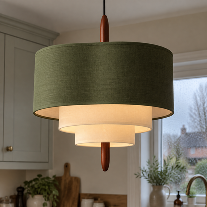 Rattan and linen pendant light hanging lit above a kitchen worktop on a drizzly afternoon