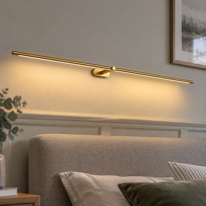 Cordless linear bedside wall lamp fixed horizontally above a headboard and switched on