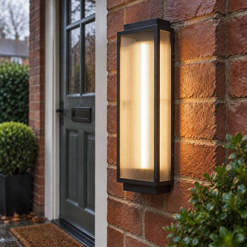 Reeded glass outdoor wall light fixed to damp brickwork beside a front door and switched on