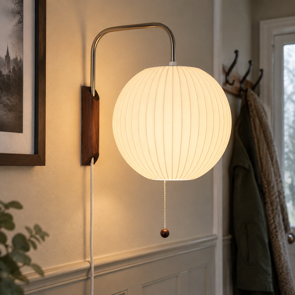 White ribbed bubble wall sconce lit on a panelled hallway wall
