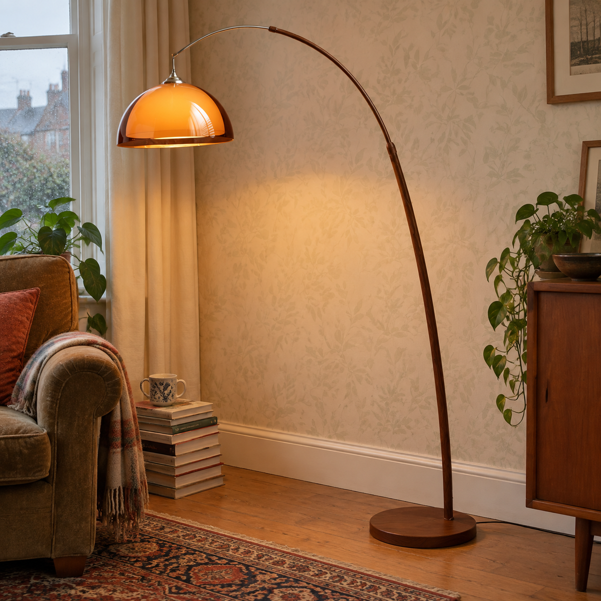 Mid century retro floor lamp standing lit beside a worn armchair in a British sitting room
