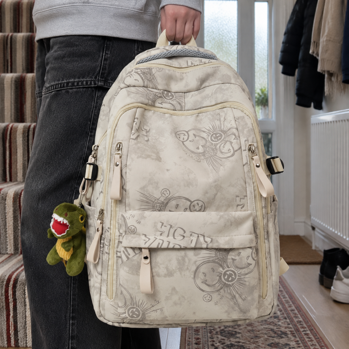 Teenager carrying an urban graphic print rucksack by its handle in a British hallway