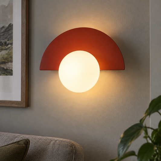 Semicircle Nordic wall sconce casting a warm wash on a sitting room wall above a sofa