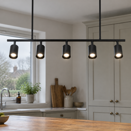 Minimalist spot pendant light hanging on its cord above a scratched oak kitchen island worktop, shade facing down