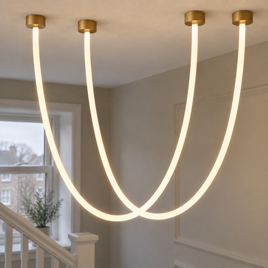 Draped LED line chandelier hanging in lit swags down a painted stairwell beside a white-painted banister