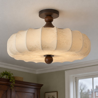 Beige linen drum ceiling light with a walnut ring fixed flush to a bedroom ceiling below the picture rail