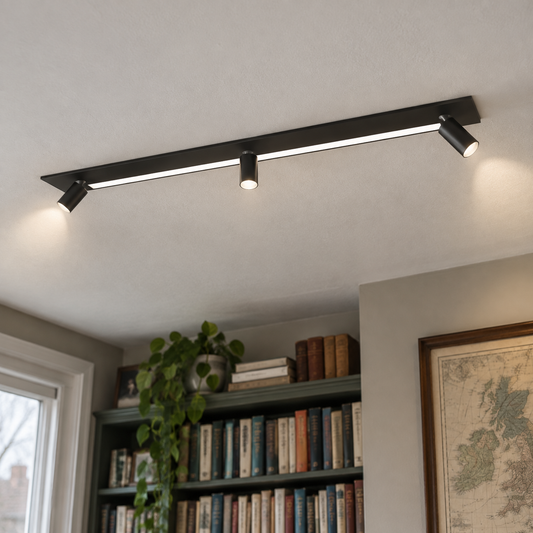 Recessed black magnetic track with adjustable smart spotlight heads in a study ceiling above a crowded bookcase