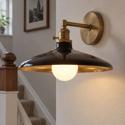 Tapered industrial metal wall sconce on a painted stairwell wall, shade mouth facing outward and down