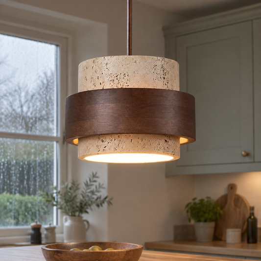 Travertine and walnut pendant light hanging over a timber kitchen island, yellow-beige stone shade with walnut cap lit on a rainy morning