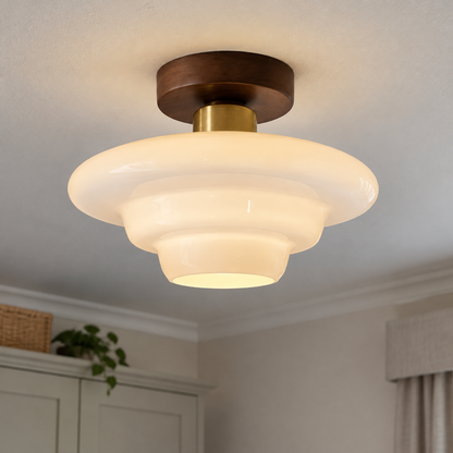 Scandinavian walnut and glass ceiling light fitted flush to a bedroom ceiling, warm wood frame with glass diffuser lit softly
