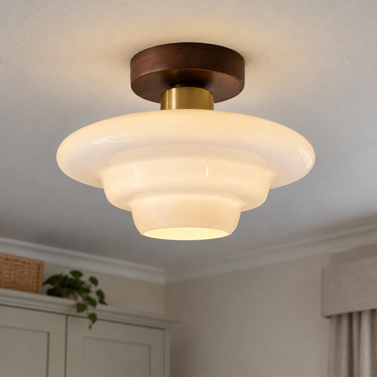 Scandinavian walnut and glass ceiling light fitted flush to a bedroom ceiling, warm wood frame with glass diffuser lit softly