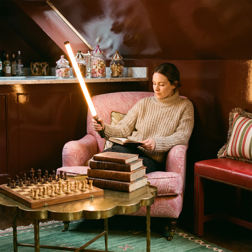 Woman holding the glowing 360° LED handheld light stick in a cosy lacquered snug