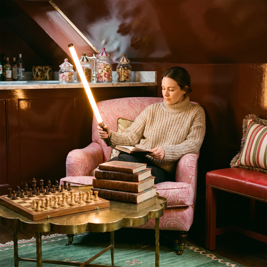 Woman holding the glowing 360° LED handheld light stick in a cosy lacquered snug